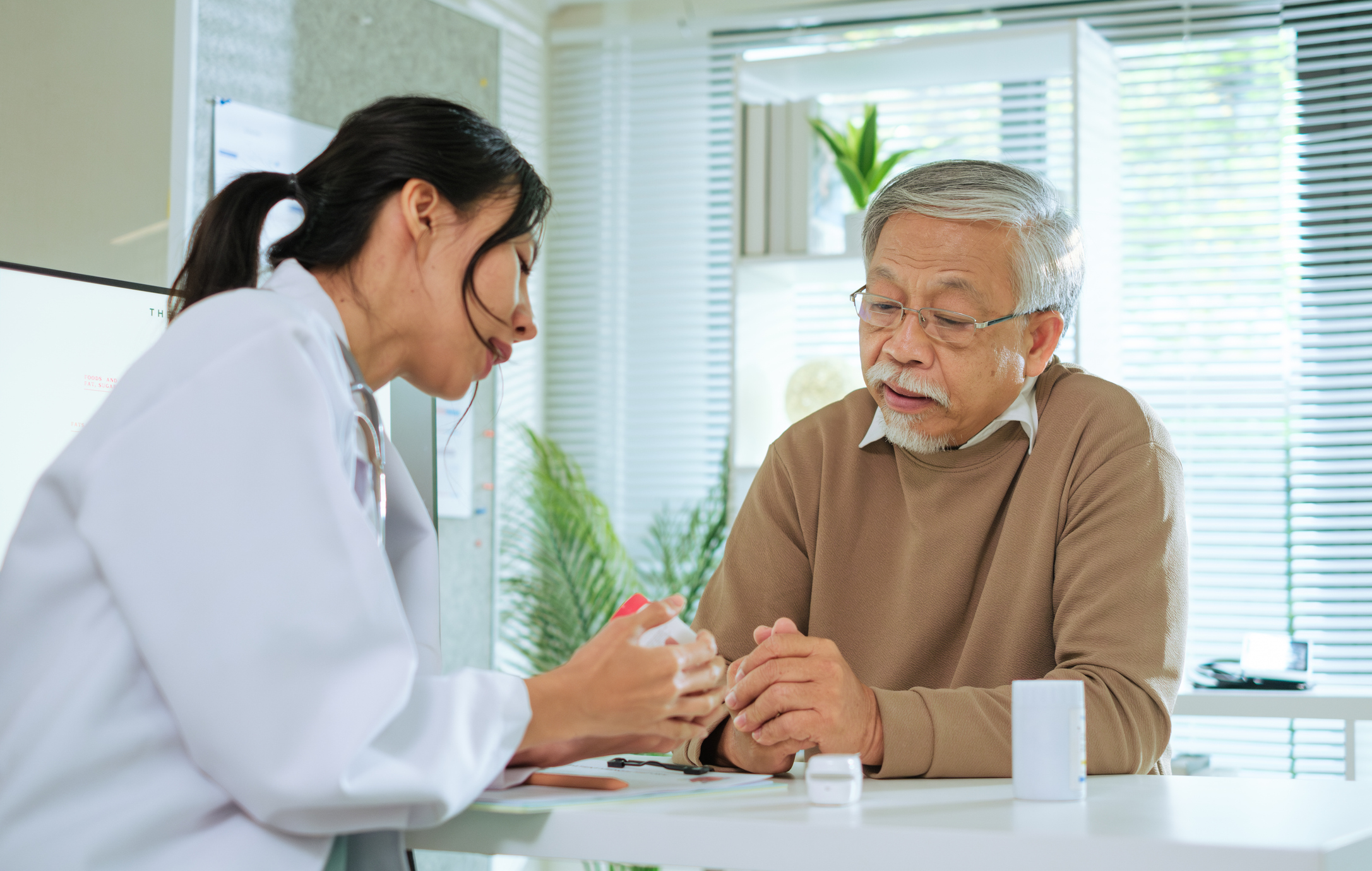 Doctor Explaining Medication to Senior Patient During Medical Consultation