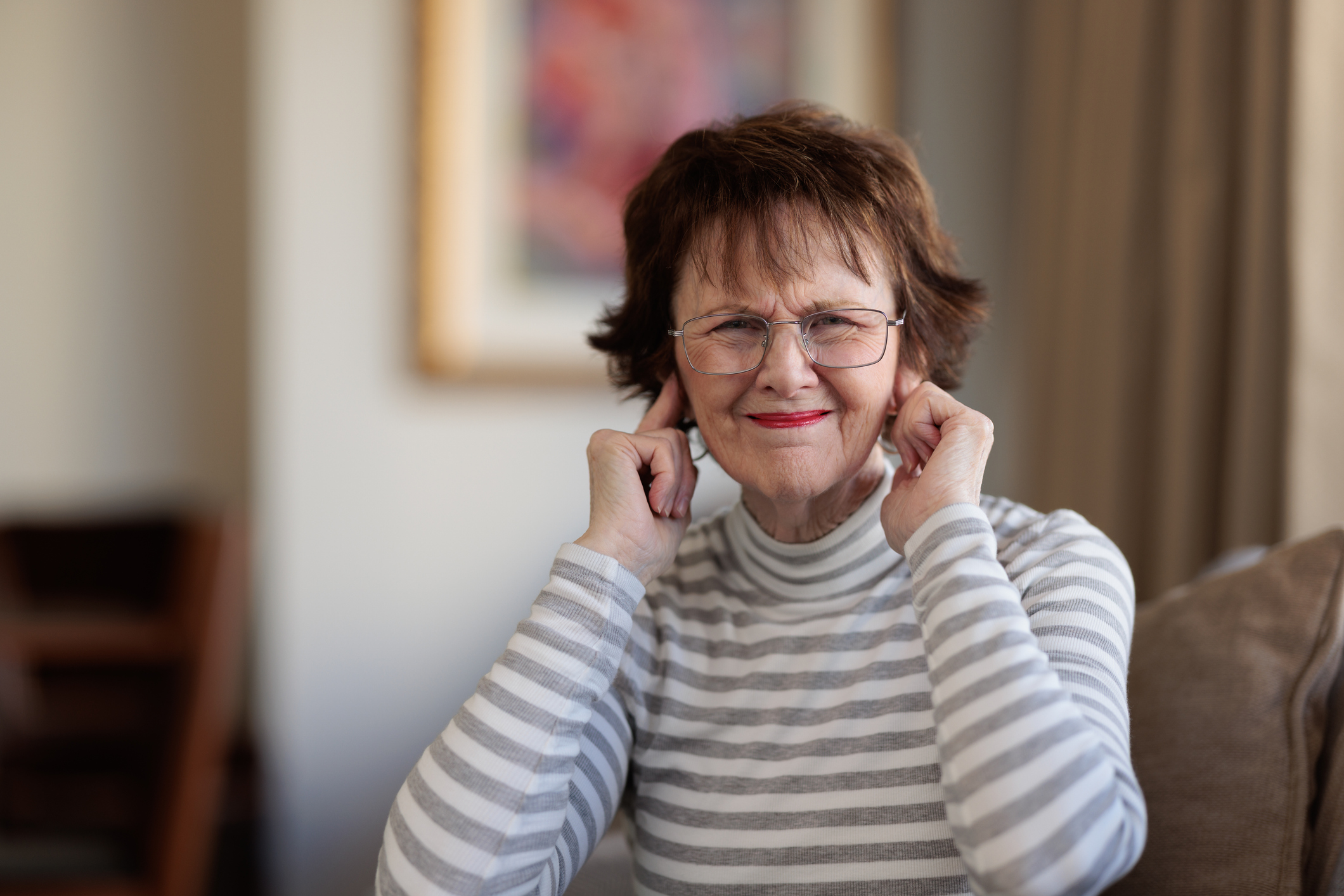 Senior woman blocking her ears with her fingers