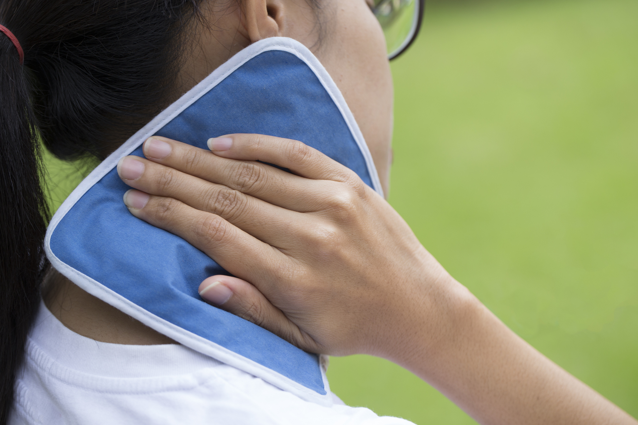 woman putting an ice pack on her neck pain